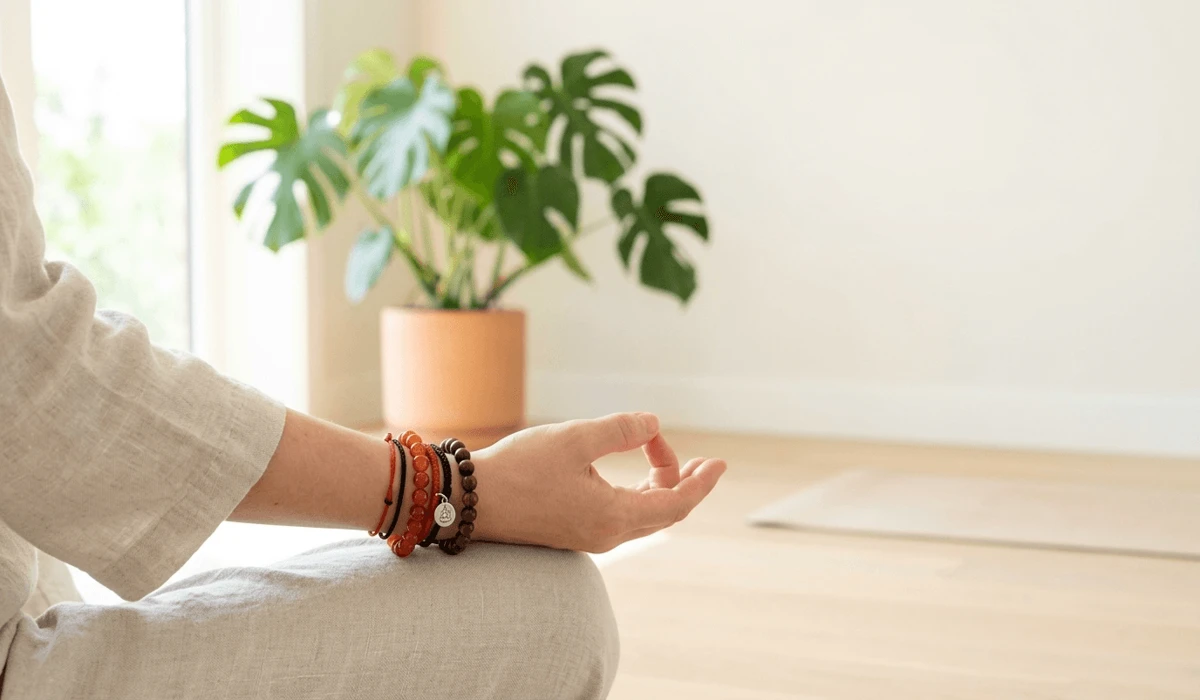 A person wearing Buddhist bracelets on their left wrist during meditation, illustrating the use of spiritual jewelry for modern mindfulness.