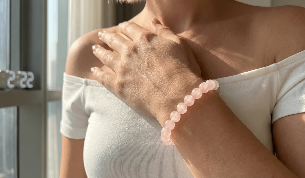 A woman wearing a Rose Quartz bracelet on her left hand to receive the balancing energy of angel number 222.