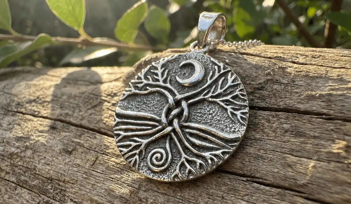 Detailed silver Tree of Life necklace on wood representing the connection between soul roots and spiritual growth.
