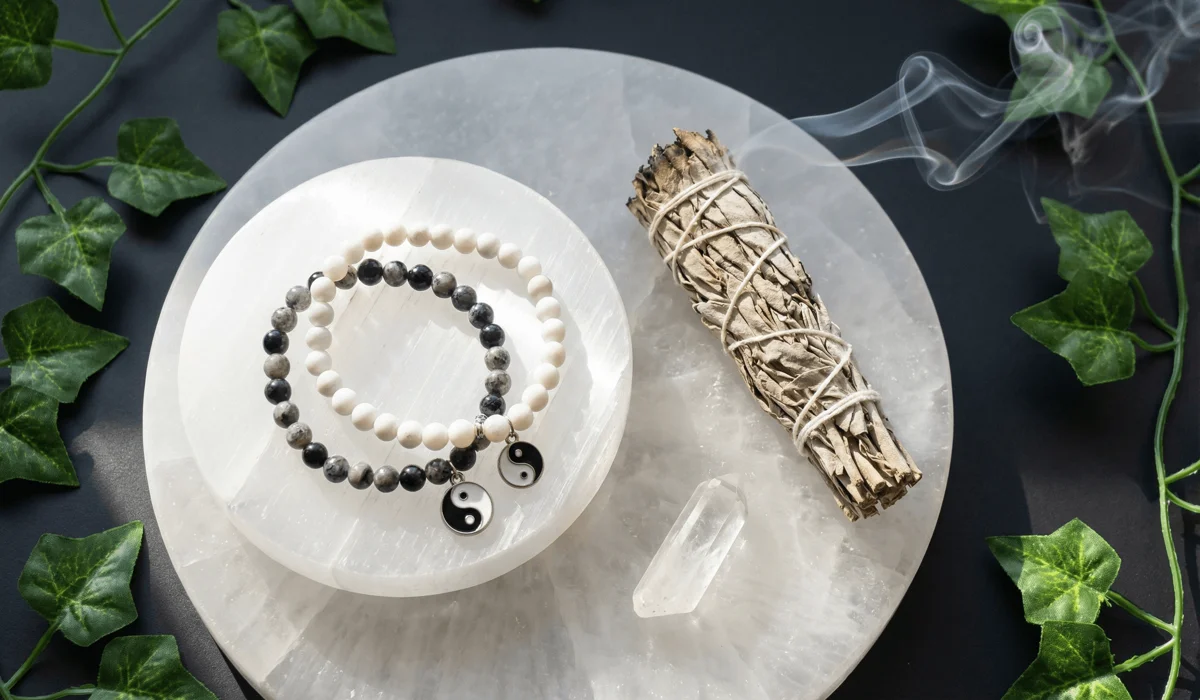 Handcrafted Yin Yang bracelets being cleansed with sage and a selenite plate to maintain energetic clarity.