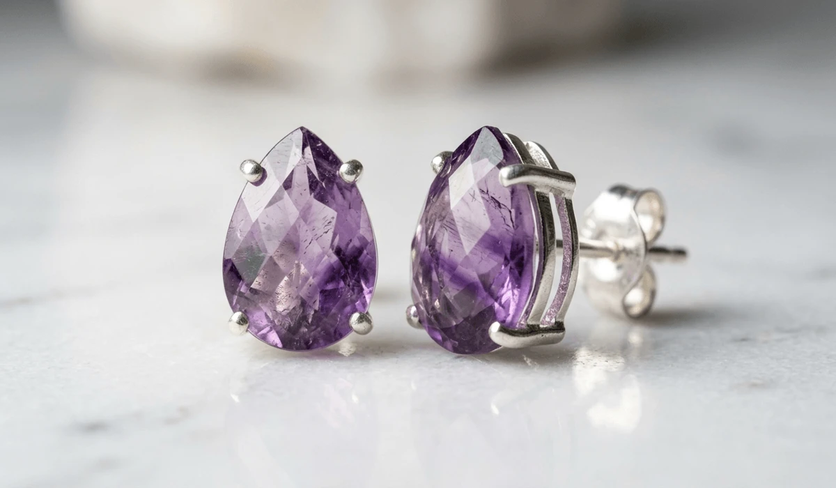 Close-up of genuine natural Amethyst stud earrings showing deep purple color zoning and crystal inclusions.