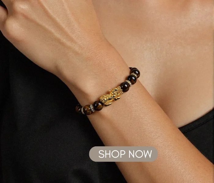 Woman wearing the Wealth-Attracting Pixiu Tiger&rsquo;s Eye Bracelet - The Light of Success on her wrist, with a "SHOP NOW" button overlay.