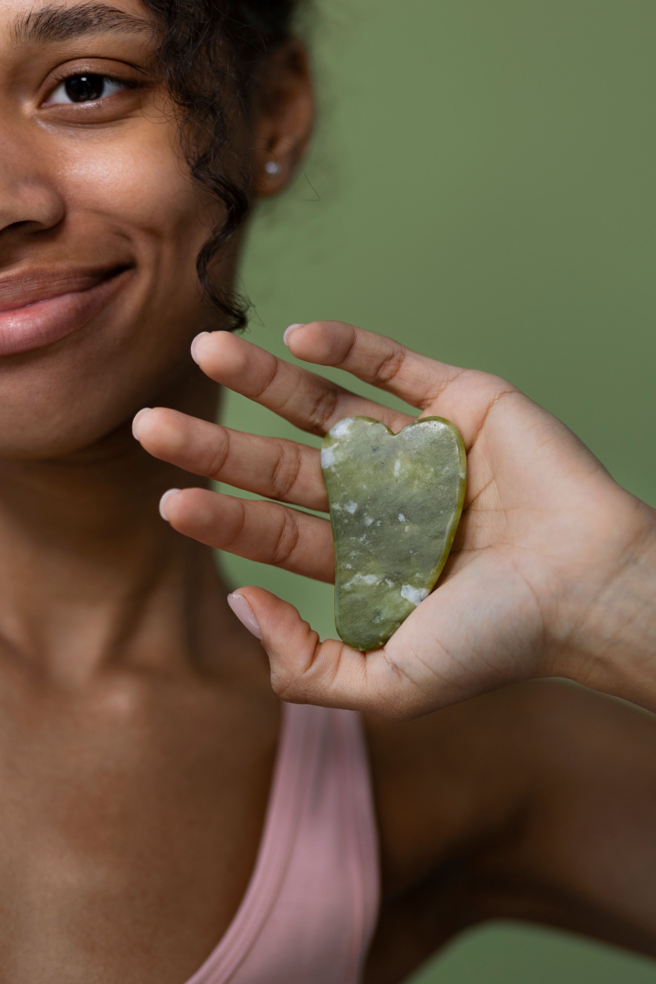 Jade gua sha tool on a soft surface