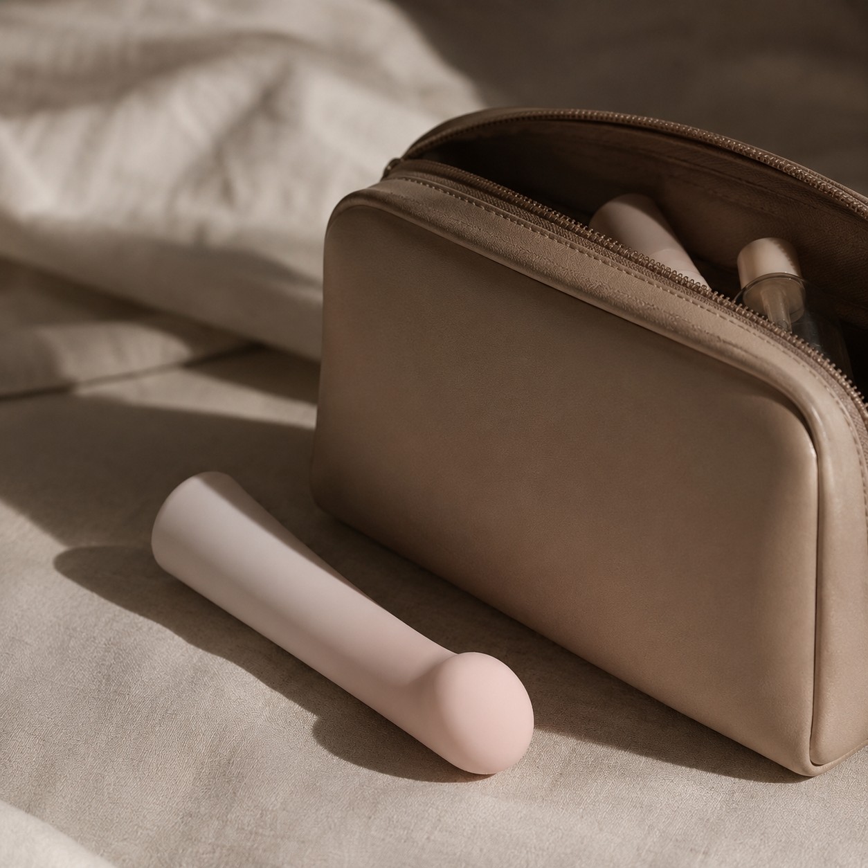 Person holding the Envy vibrator against a warm blush background