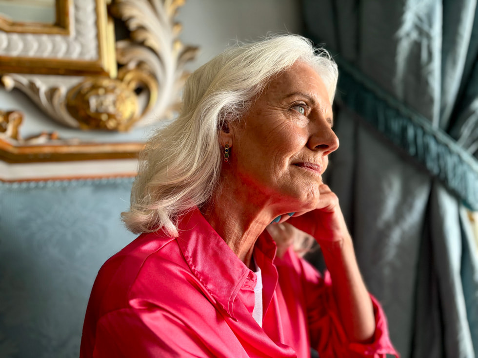 A portrait taken on iPhone 15 shows a person posing with their hand beneath their chin.