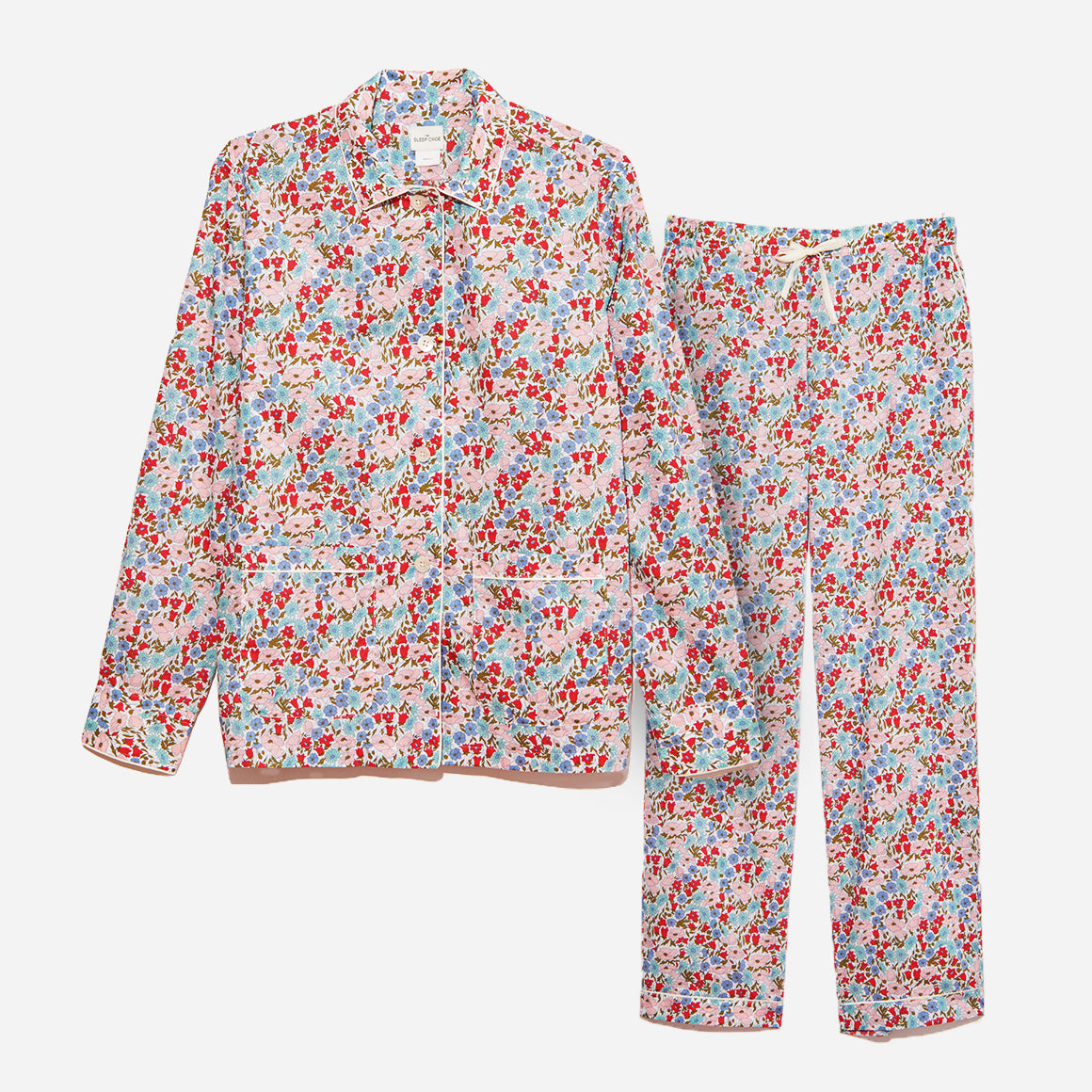 The pajama set includes a classic button-up top with a collar, two patch pockets, and functional button cuffs. The matching pair of pants features a comfortable elastic waistband, drawstring, and side-seam pockets. The long sleeves offer extra coverage and warmth for cooler evenings.