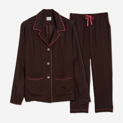 The pajama set includes a classic button-up top with a collar, two patch pockets, and functional button cuffs. The matching pair of pants features a comfortable elastic waistband, drawstring, and side-seam pockets. This cozy pj set is a timeless and stylish look that is perfect for lounging at home.