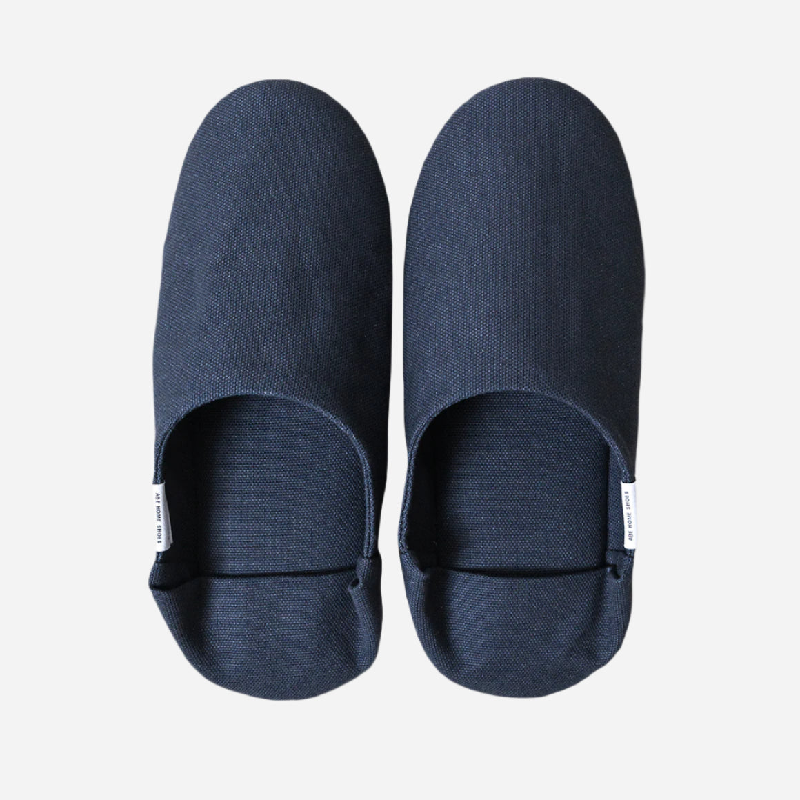Top-down view of navy slippers with heel flap folded down. Shot against a white background.