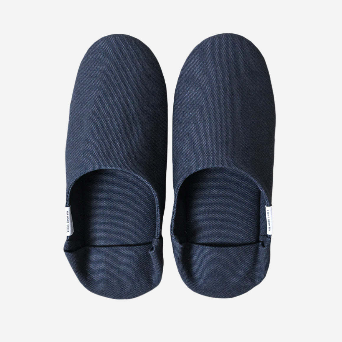 Top-down view of navy slippers with heel flap folded down. Shot against a white background.