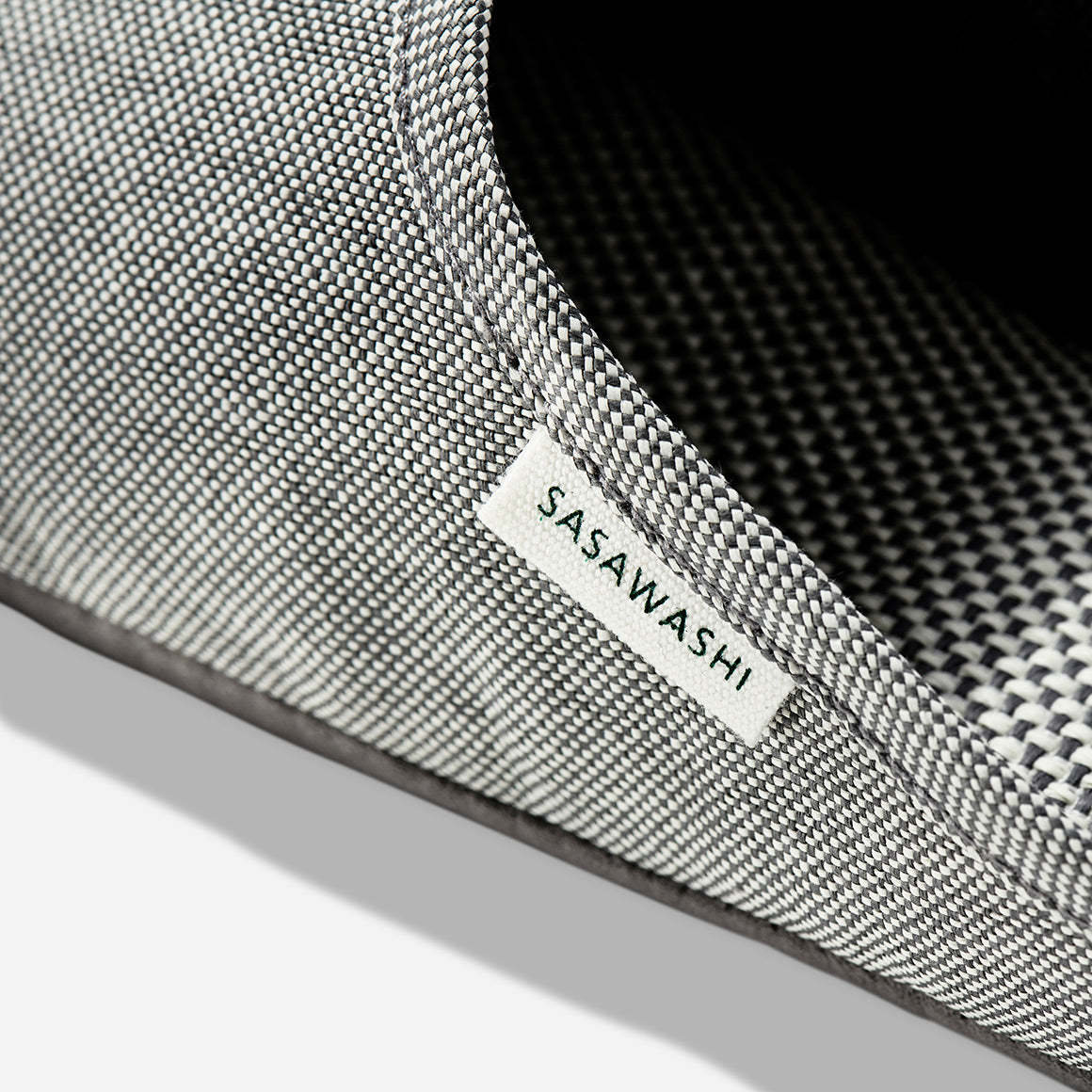 Up-close image of the side of a light grey slipper with Sasawashi written in black on a white tag.