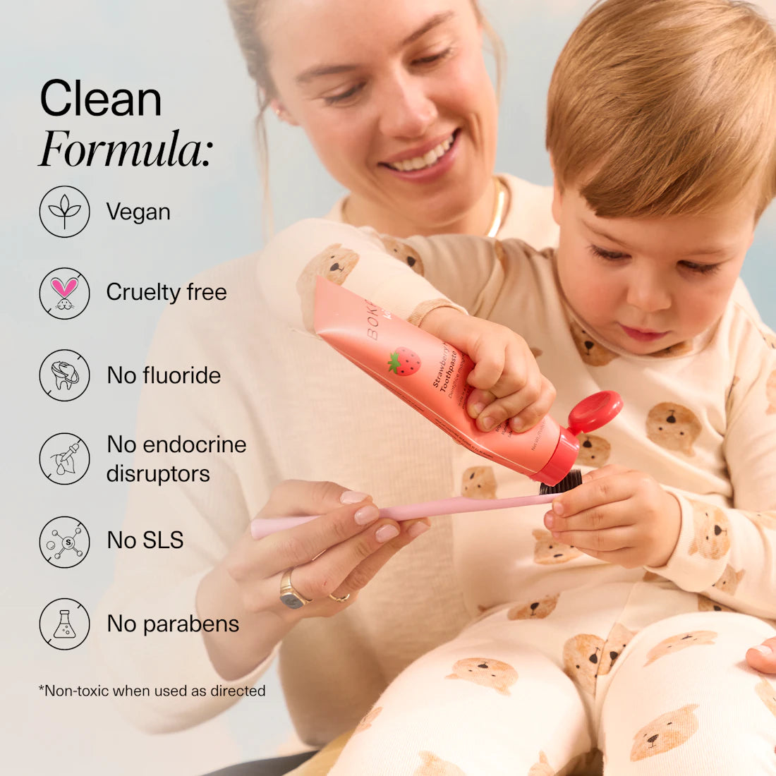 A smiling woman helps a toddler brush, enjoying n-Ha Toothpaste Family 3 Pack’s kid-approved flavors.