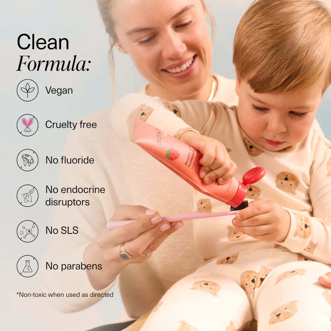 A smiling woman helps a toddler brush, enjoying n-Ha Toothpaste Family 3 Pack’s kid-approved flavors.