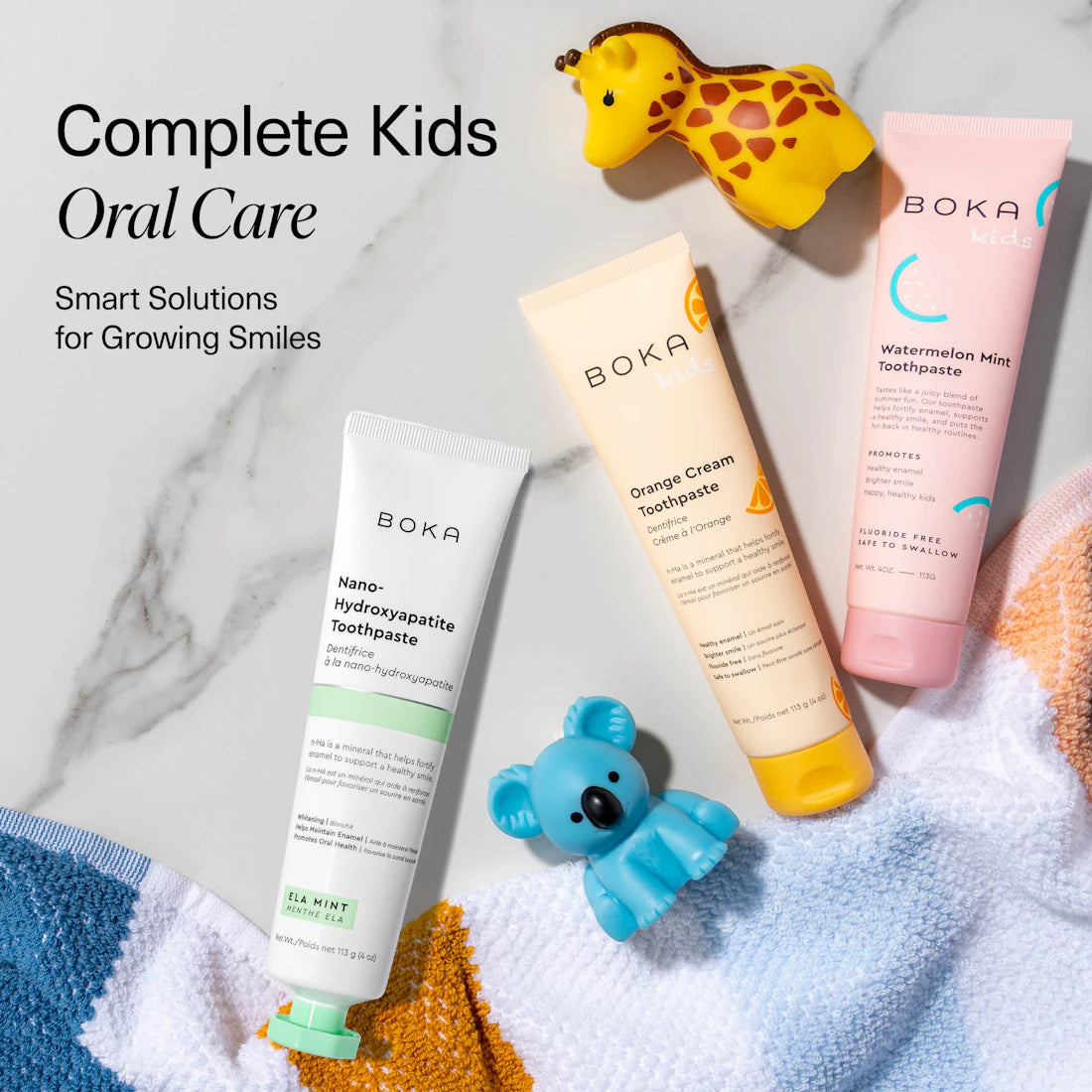 N-Ha Toothpaste Family 3 Pack with kid-friendly flavors, toy giraffe, koala, and colorful towel included.