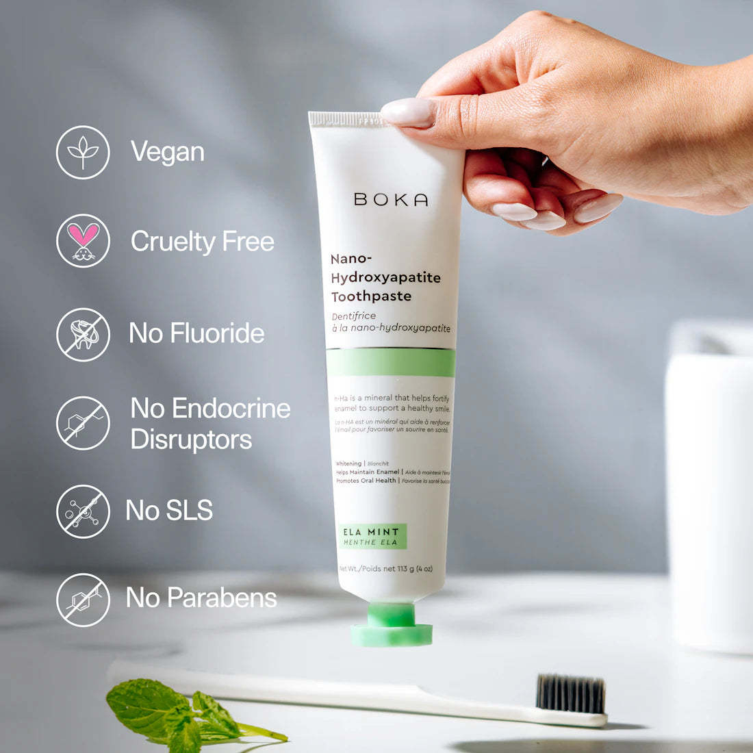 Hand holding Ela Mint n-Ha Toothpaste; packed with nano-hydroxyapatite for better oral health.