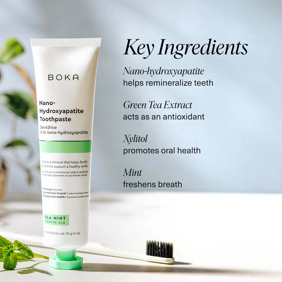 A tube of Ela Mint n-Ha Toothpaste stands by a toothbrush; key ingredients are listed.