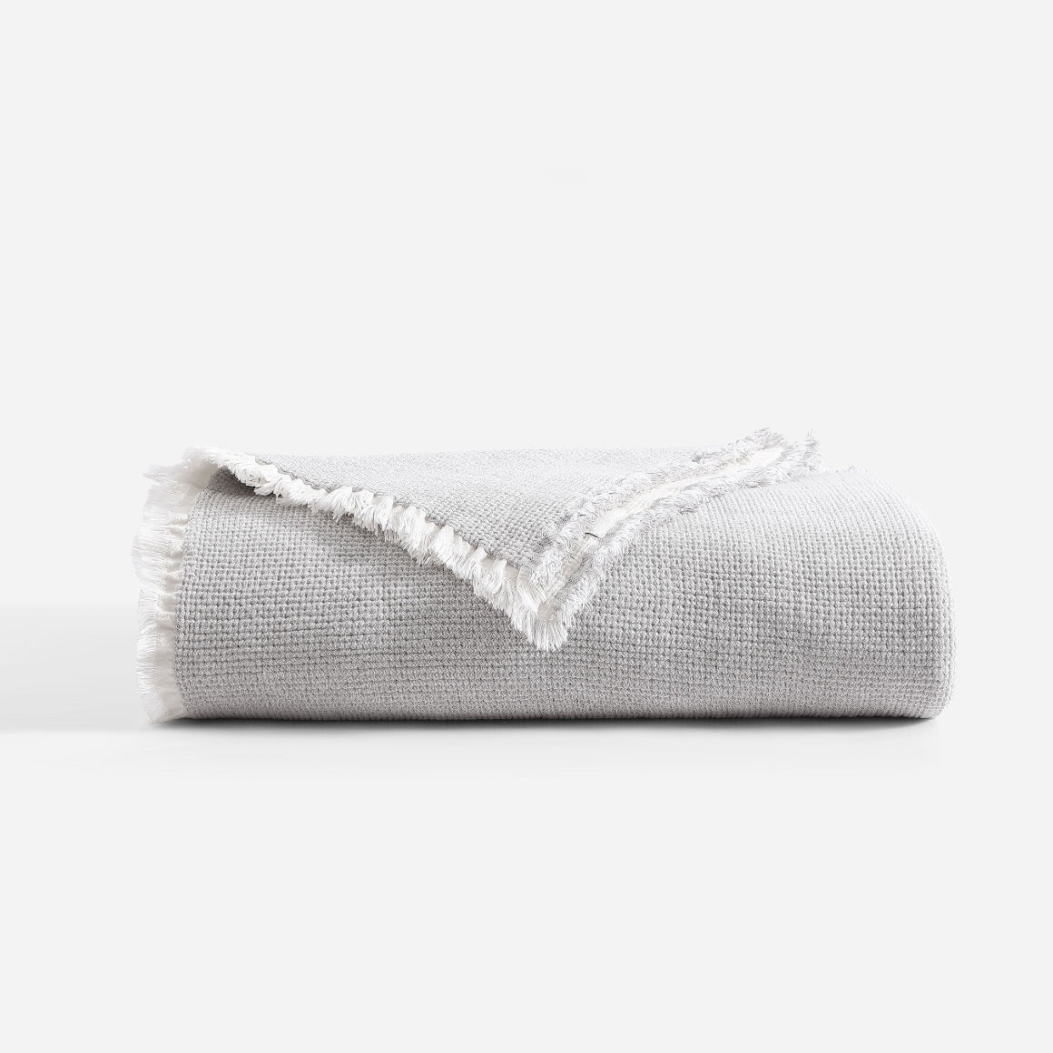 Gray textured blanket with white lace trim on a white background