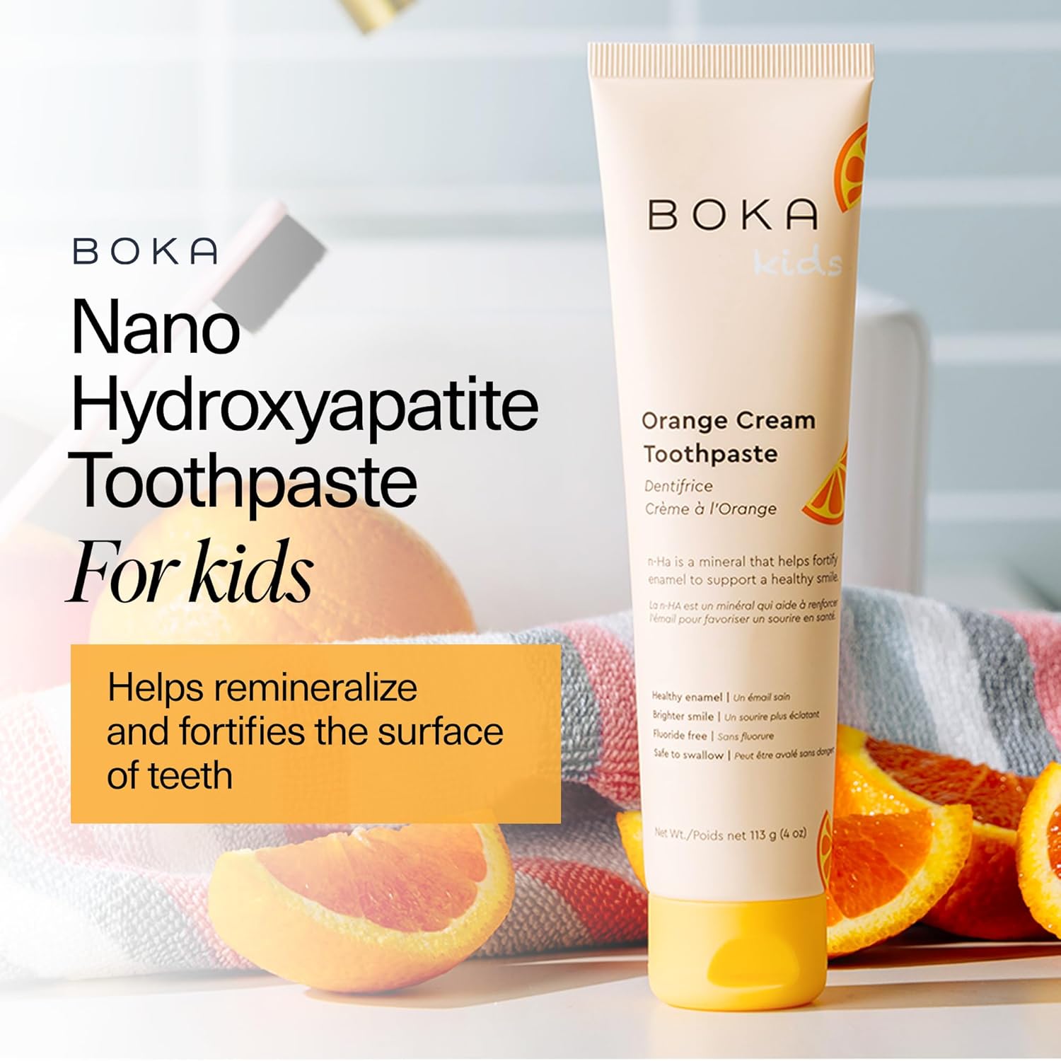 Tube of Orange Cream n-Ha Toothpaste for kids, orange flavor, with oranges in the background.