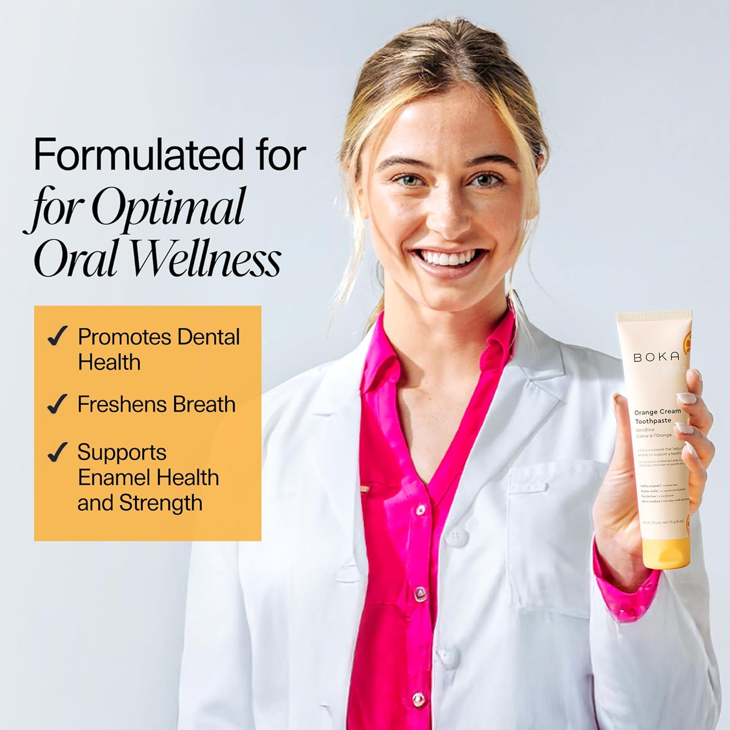 Woman in a white coat holds Orange Cream n-Ha Toothpaste; text highlights fresh breath and strong enamel.