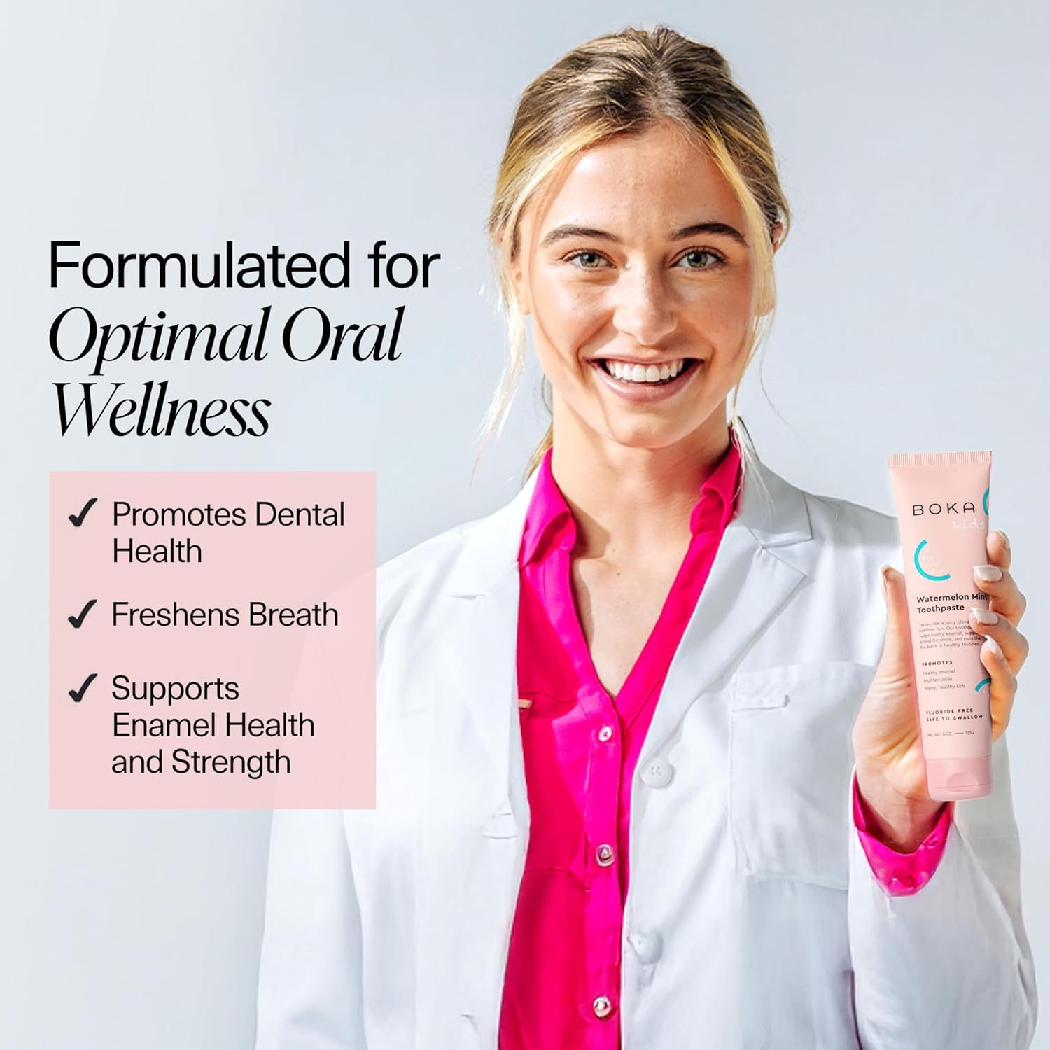 A smiling woman in a lab coat holds Watermelon Mint n-Ha Toothpaste, fluoride-free with listed benefits.