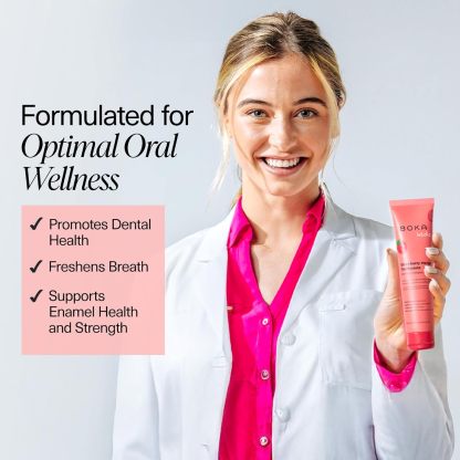 Smiling woman in lab coat holds Strawberry Mango n-Ha Toothpaste; promotes dental health and fresh breath.