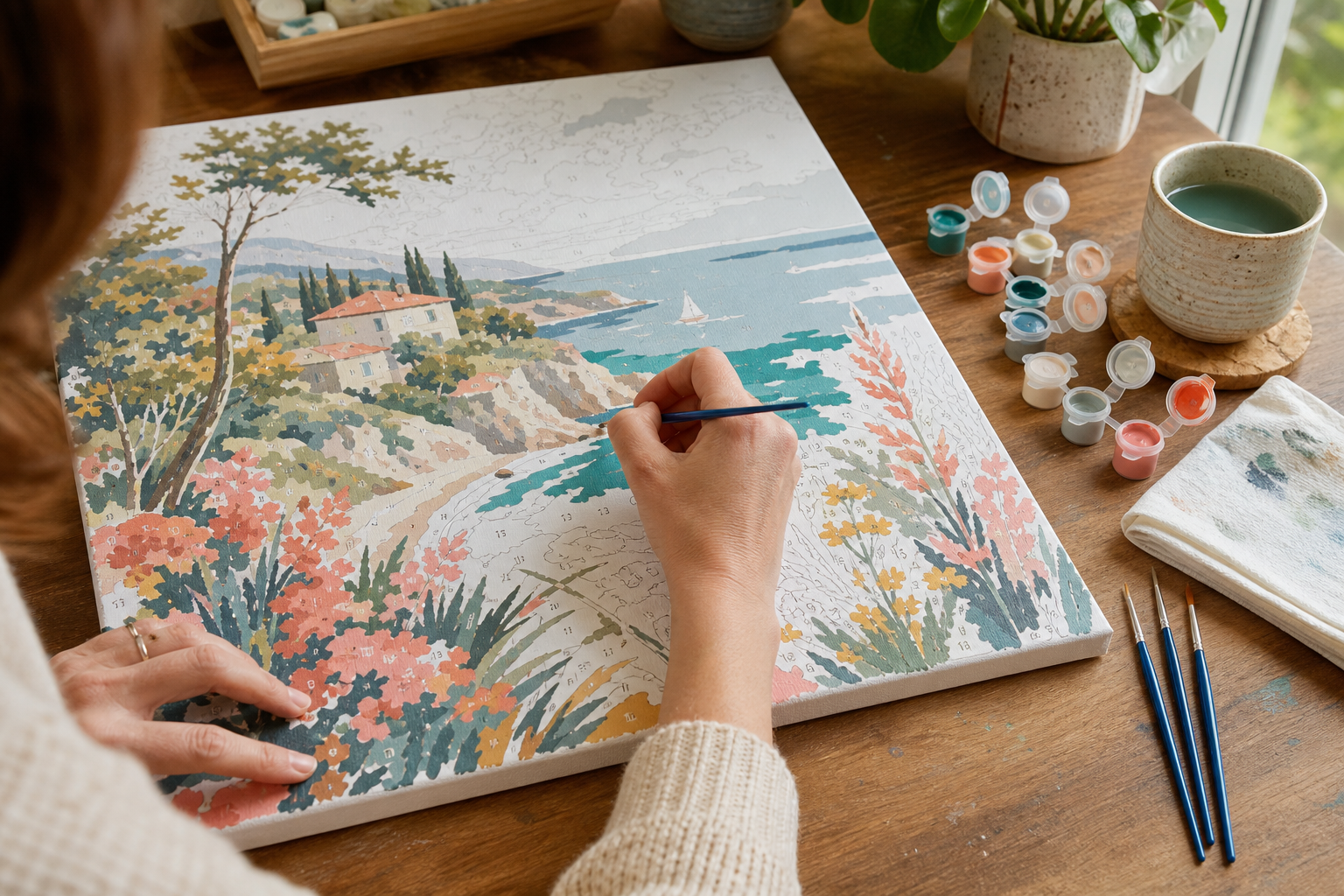 Beginner painting a numbered landscape canvas with acrylic paints and fine brushes