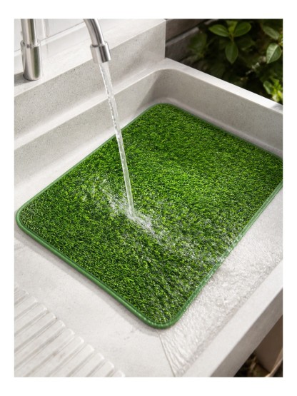 Havomi TurfEase dog potty mat being rinsed clean