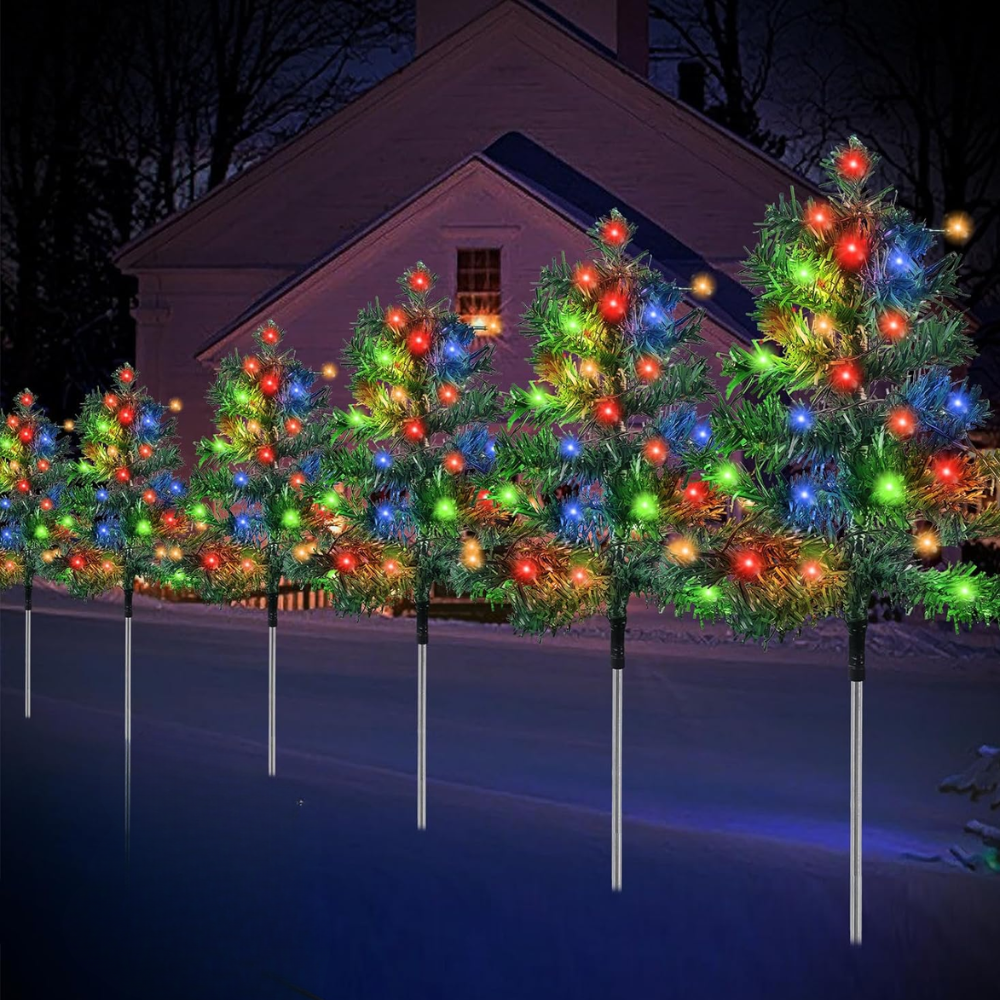 Six solar Christmas tree pathway lights glowing with multicolor C6 LEDs lined along a residential driveway at night