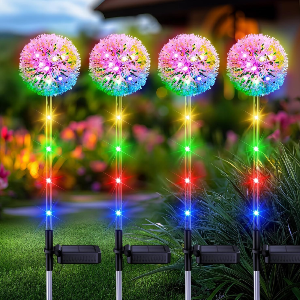 Four solar dandelion garden pathway lights with round multicolor LED globes staked in garden bed, daytime