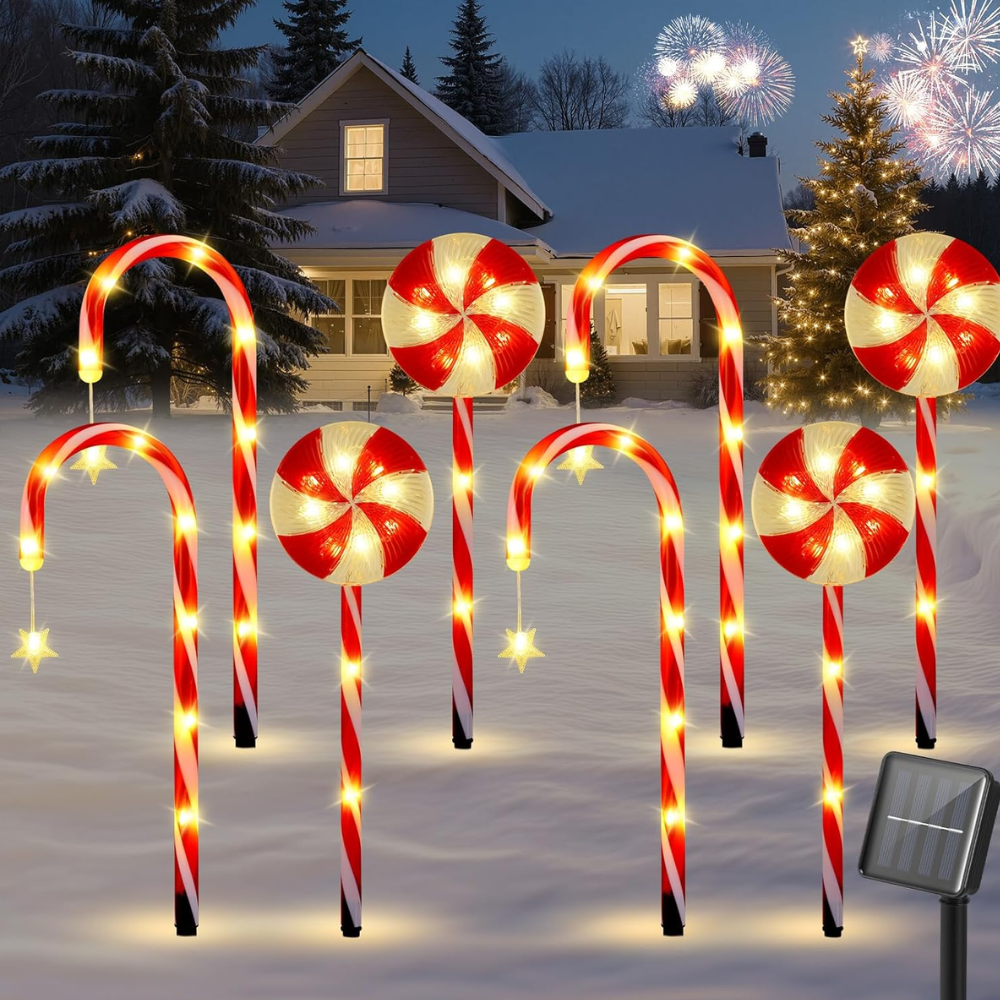 Candy cane and peppermint swirl solar Christmas pathway stake lights lining snowy yard with warm white LEDs