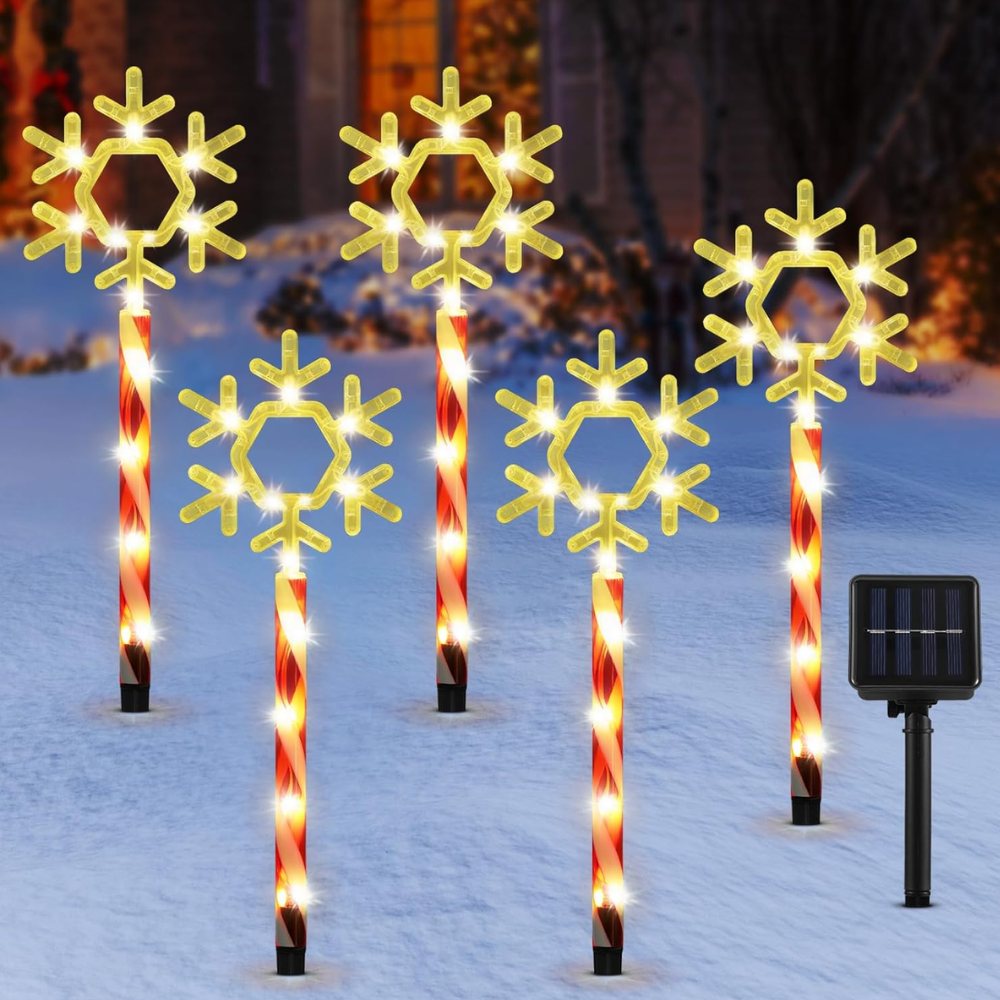 Five solar Christmas pathway lights with gold snowflake toppers on red-striped candy cane poles, product shot against white background with solar panel