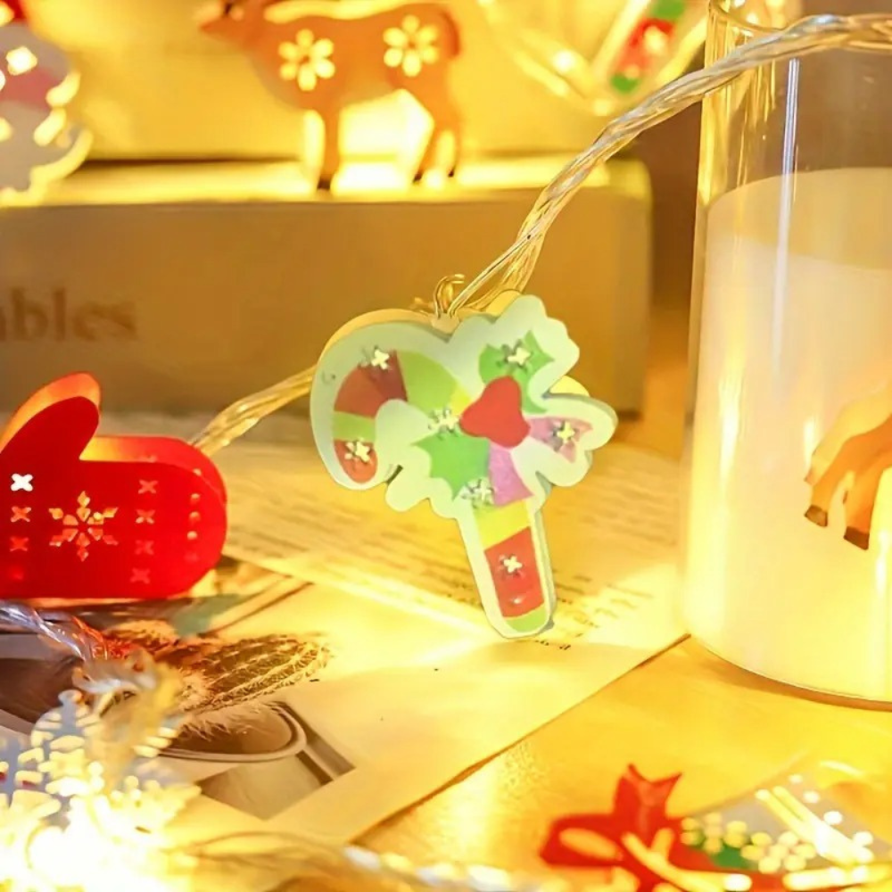 Close-up of battery powered Christmas LED string light pendant showing a candy cane with colorful holiday character details lit on the wire