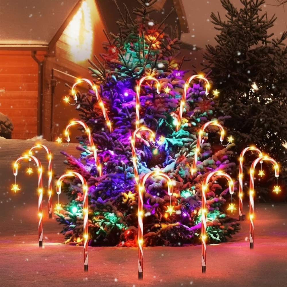 Solar candy cane pathway lights staked around a large decorated Christmas tree in a snowy yard with star accent lights