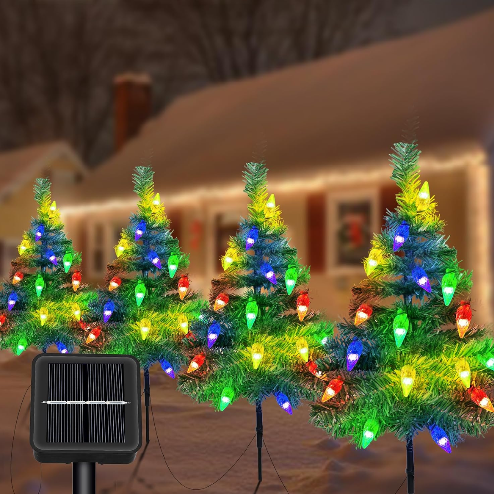 Pack of 4 solar outdoor Christmas tree pathway lights with multicolor C6 strawberry LED bulbs staked in front of a lit house