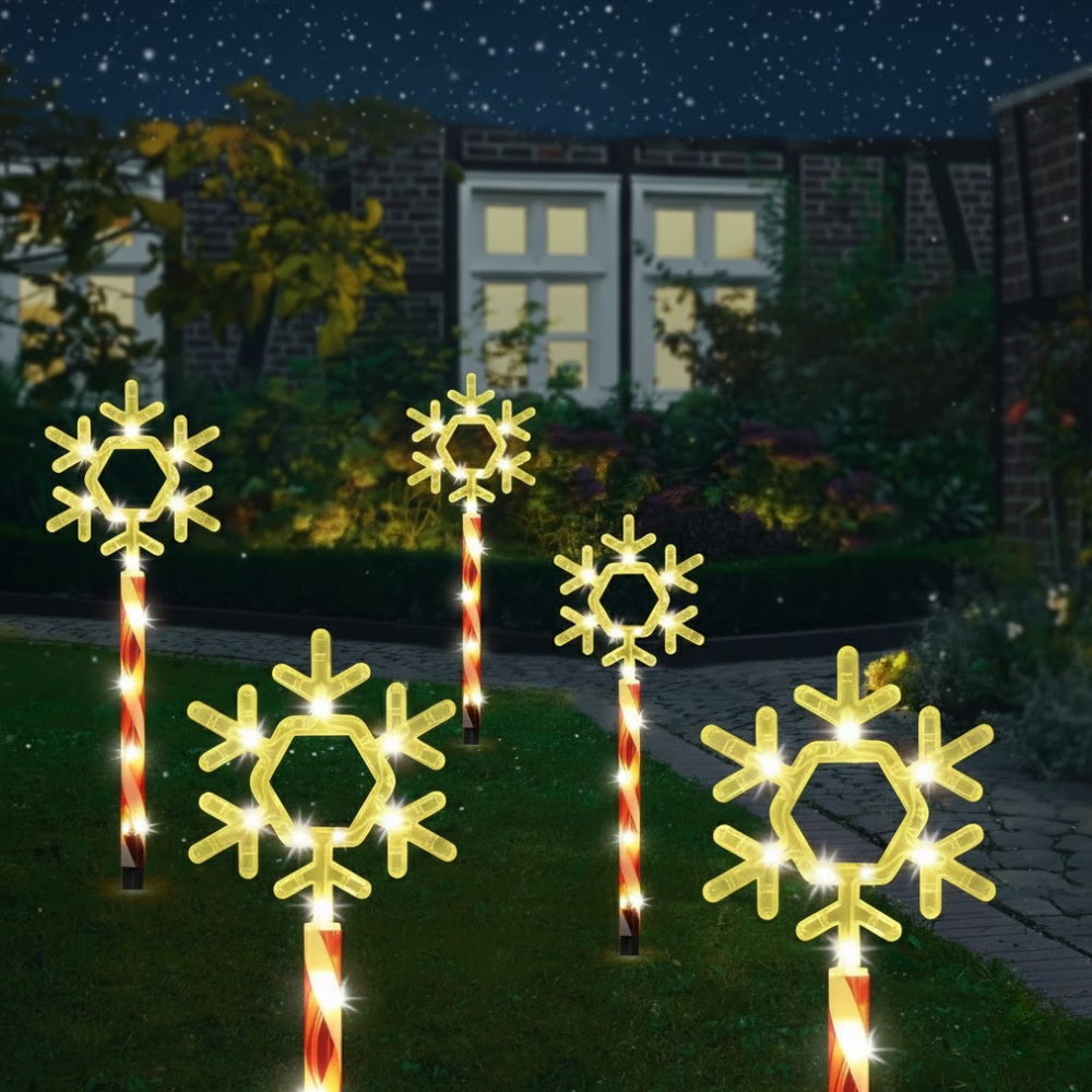 Solar Christmas garden stake lights with gold snowflake toppers on striped poles at night, illuminated warm white against a house facade