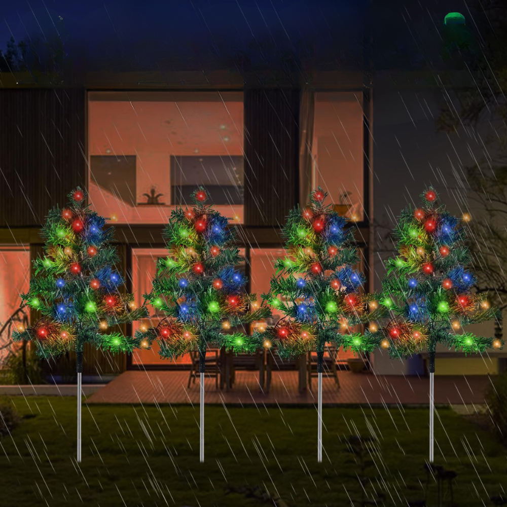 Six solar Christmas tree stake lights with multicolor C6 LEDs displayed along a garden fence in rainy night weather