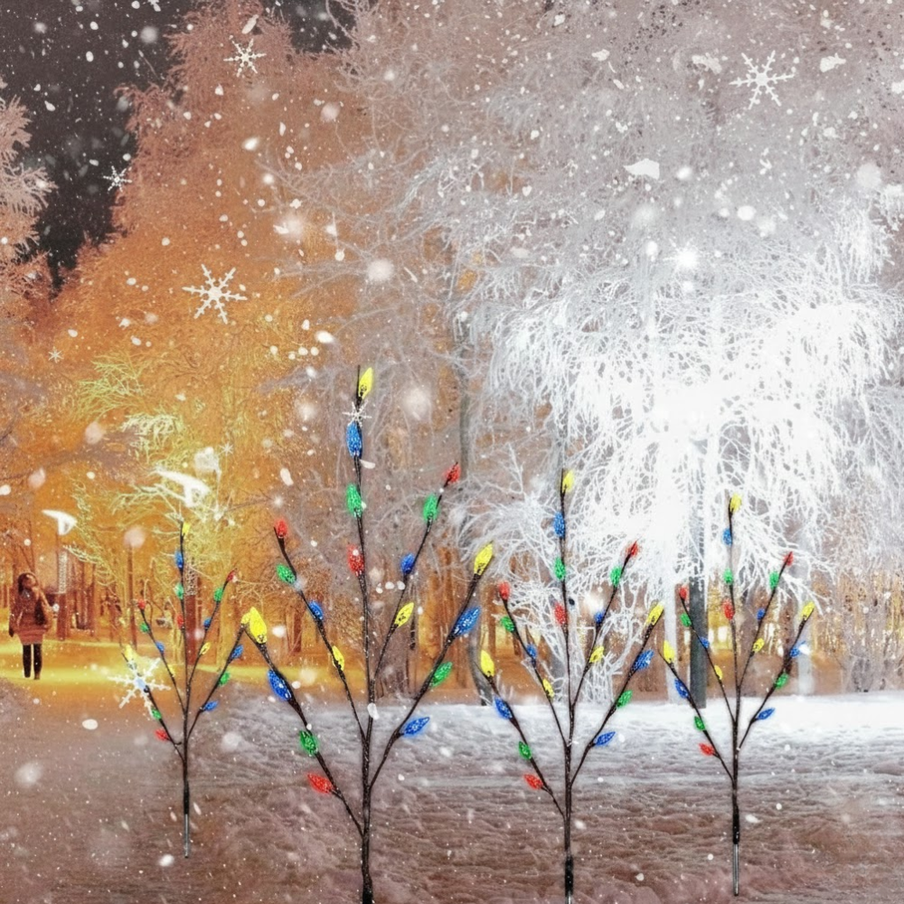 Four solar branch pathway lights with colorful LED berry bulbs staked in a snowy park with warm bokeh lights and falling snow