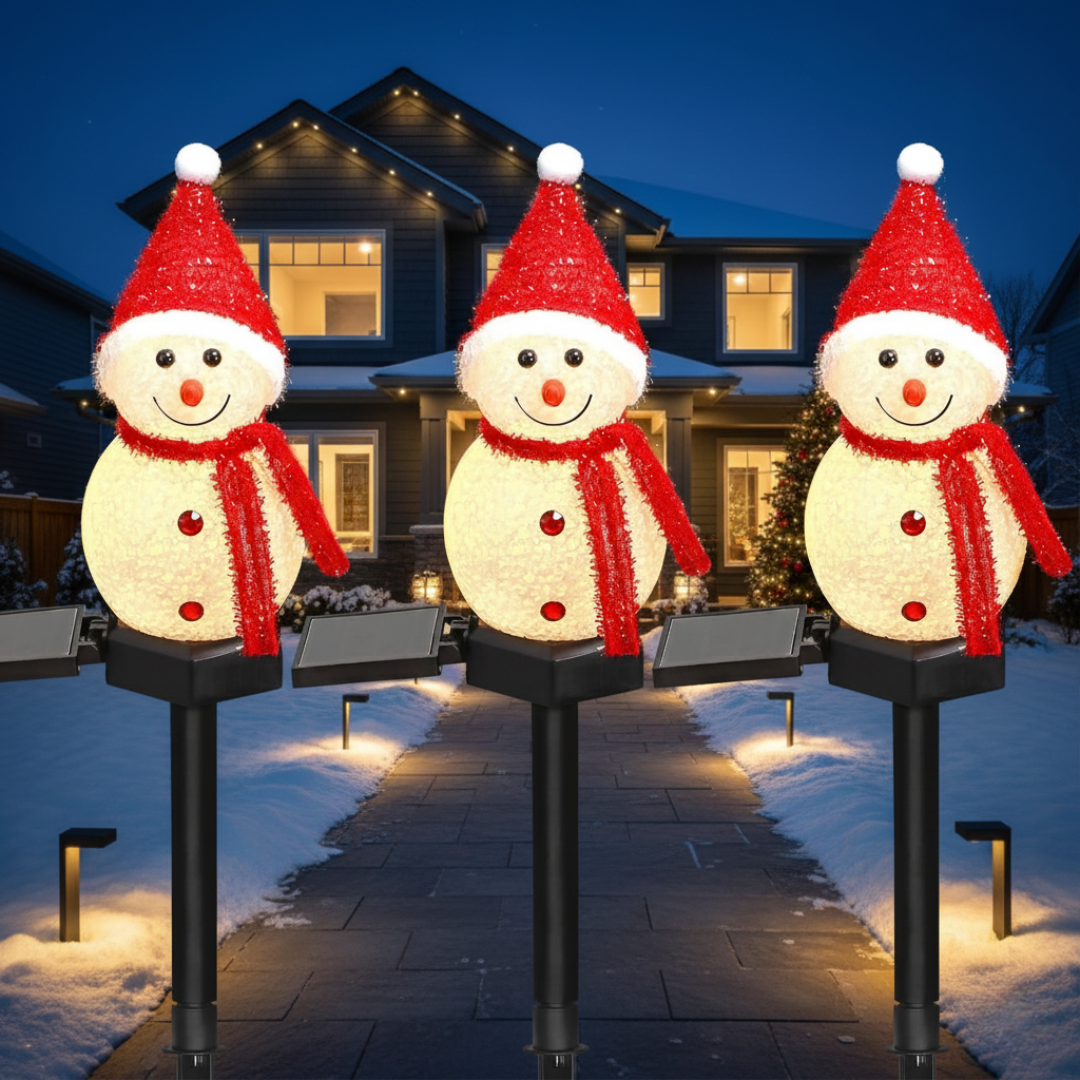 Solar snowman Christmas pathway stake lights with red hats illuminating a snowy driveway leading to a festively decorated home