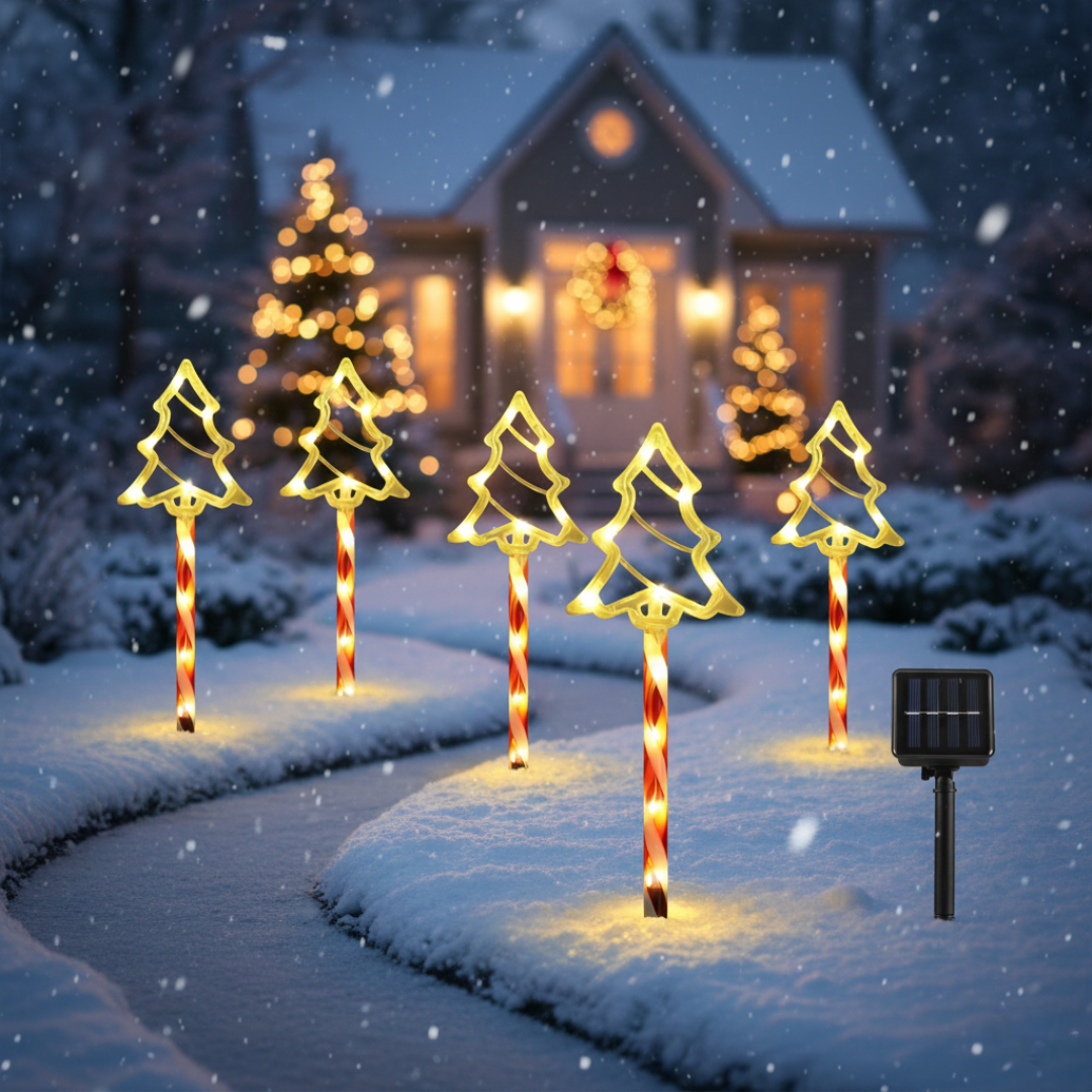 Solar Christmas tree silhouette pathway stake lights with warm LEDs on candy-cane poles arranged along a snowy path with blurred house background