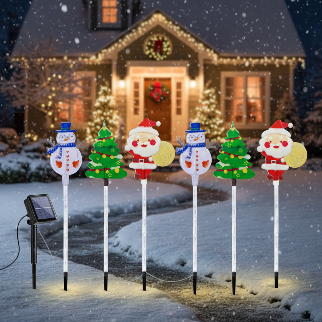 Six solar Christmas outdoor moving lights with Santa, snowman, and tree figures staked in a snowy front yard during a snowstorm