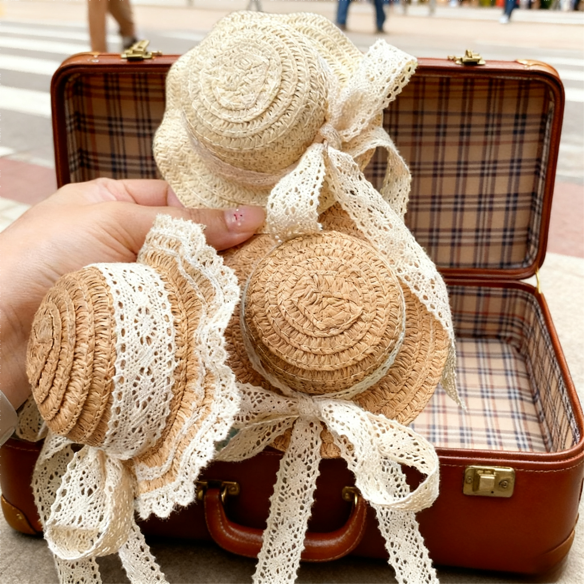 Vintage straw BJD hats with lace bows placed on a retro suitcase - Atelier Chantilly