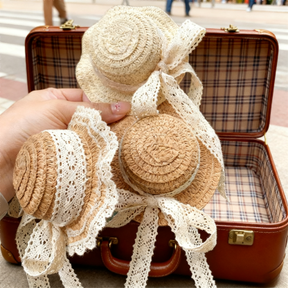 Vintage straw BJD hats with lace bows placed on a retro suitcase - Atelier Chantilly