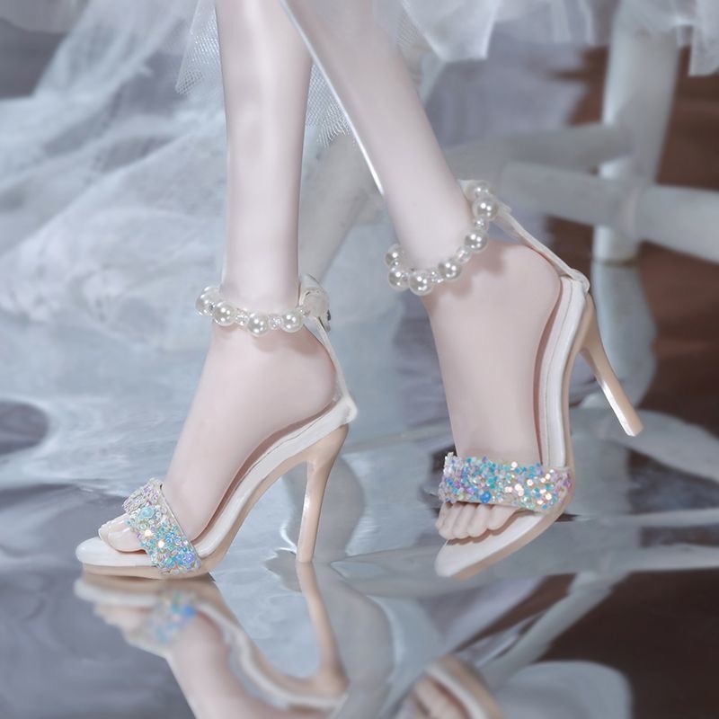 *White pearl ankle BJD doll sandals on model legs*