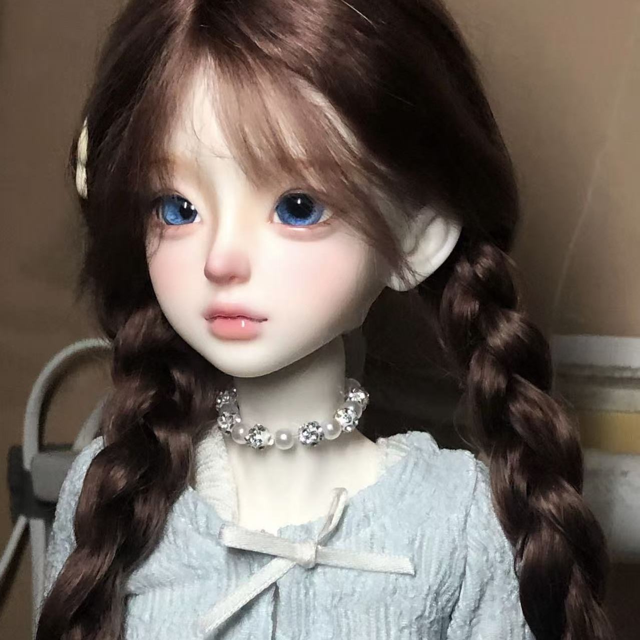 Side view of natural brown braided BJD wig on ball-jointed doll
