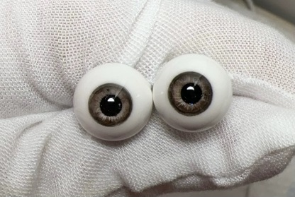 Realistic brown glass eyes for 1/3 BJD dolls resting on a white gloved hand - Atelier Chantilly