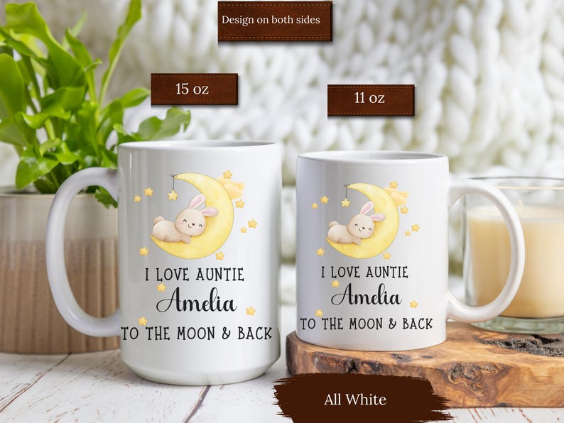 May include: White ceramic mug with a design of a bunny sleeping on a crescent moon with stars. The text "I love Auntie Amelia to the moon & back" is printed on the mug. The mug is available in 11 oz and 15 oz sizes.