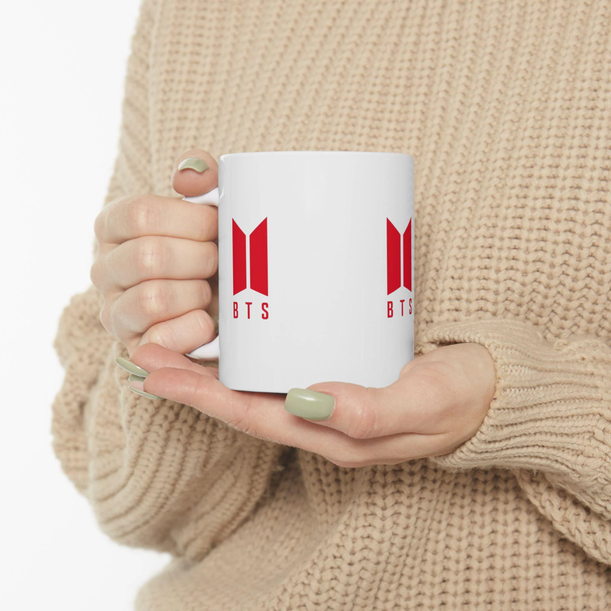 Glossy white ceramic mug with music group logo on front and handle side accents