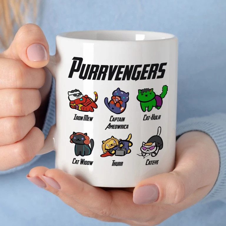 White ceramic mug featuring six cartoon cats dressed as superhero characters including Iron Mew and Captain Ameowrica