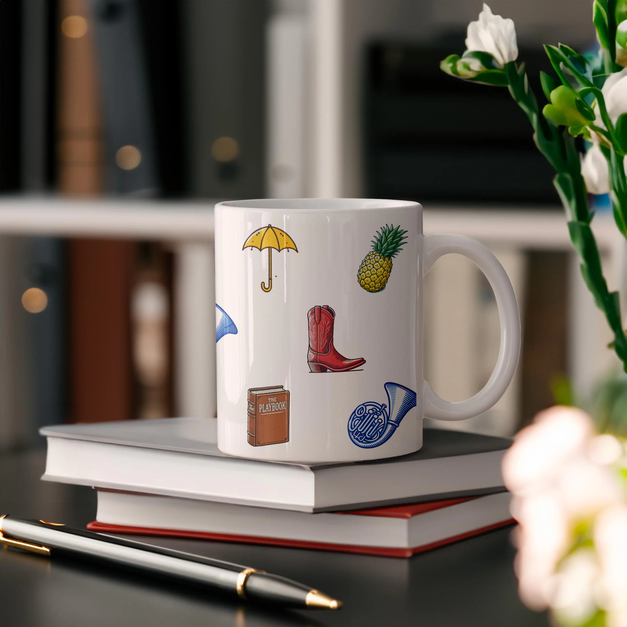 White ceramic coffee mug featuring How I Met Your Mother symbols like the yellow umbrella and blue horn on a desk with books