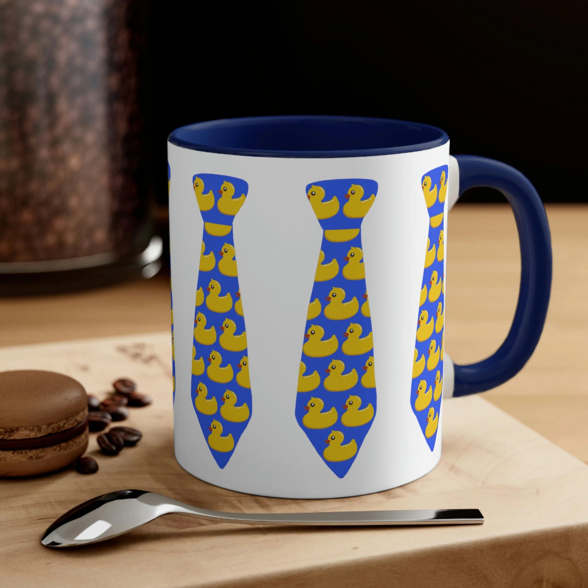 White ceramic mug with navy blue handle and interior featuring yellow rubber ducky necktie print design