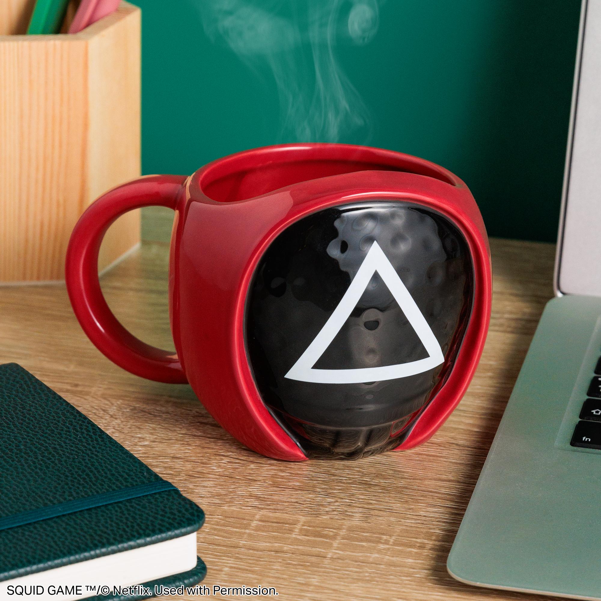 Squid Game Triangle Guard Shaped Ceramic Coffee Mug on desk with steam